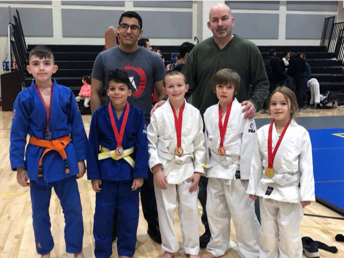 Kids showing off their medals at a judo competition